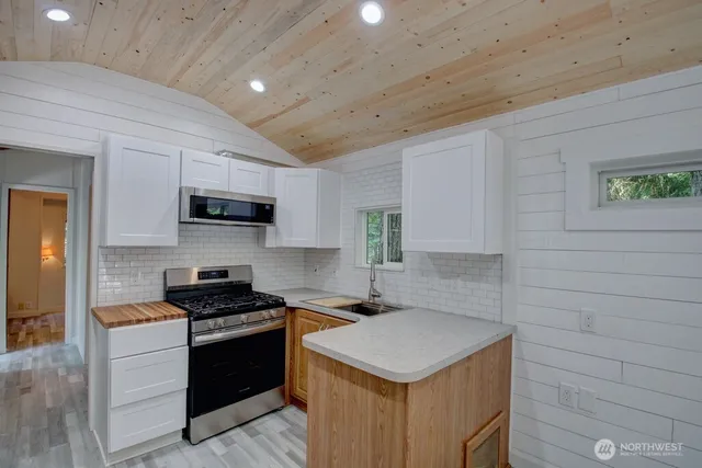 a kitchen with granite countertop a sink a stove and microwave