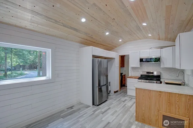 a kitchen with stainless steel appliances a sink a stove top oven a counter top space and cabinets