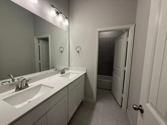 a bathroom with a double vanity sink and a mirror