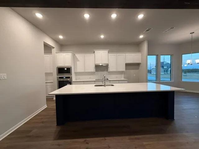 a kitchen with kitchen island a sink stainless steel appliances and cabinets