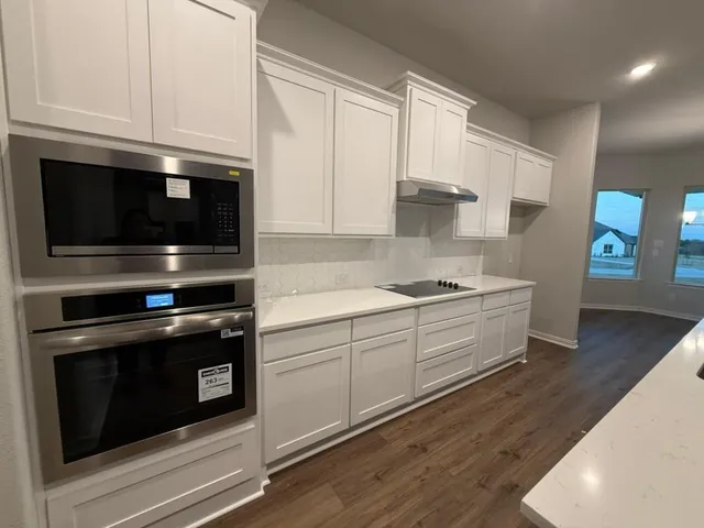 a kitchen with stainless steel appliances a stove microwave and cabinets