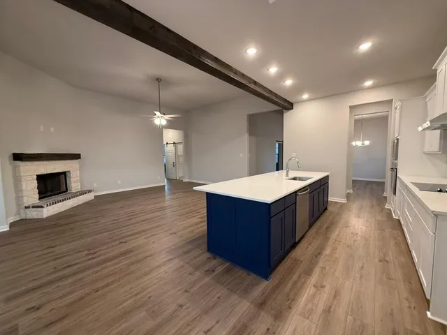 a living room with wooden floor and a fireplace