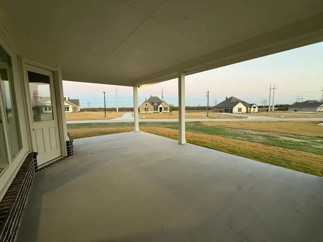 a view of an ocean with a floor to ceiling window next to a yard