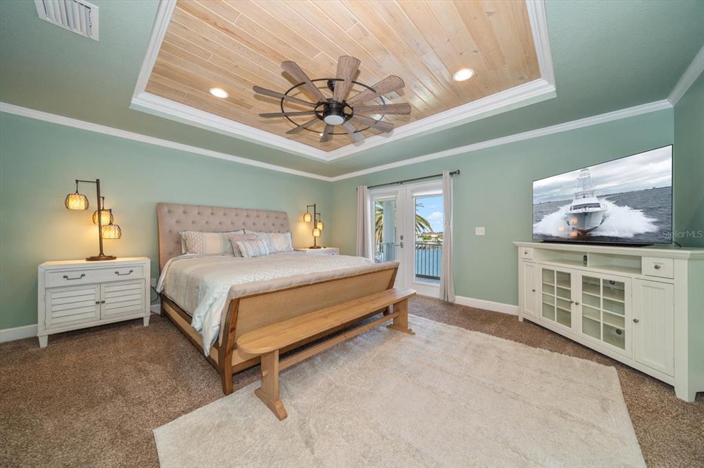 478 Harbor Drive South Indian Rocks Beach, FL 33785 - Photo 32 of 73 a spacious bedroom with a bed and a chandelier