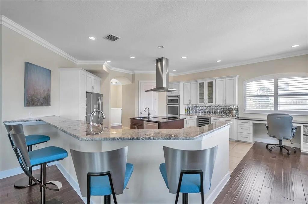 478 Harbor Drive South Indian Rocks Beach, FL 33785 - Photo 67 of 73 a kitchen with center island wooden floor and stainless steel appliances
