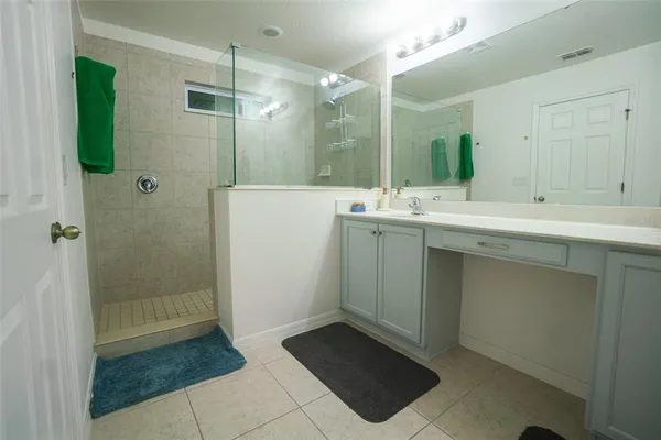 a bathroom with a shower sink and mirror