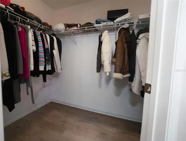 a view of walk in closet with clothes and shoes