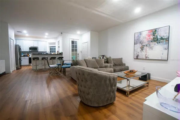 a living room with furniture and a wooden floor