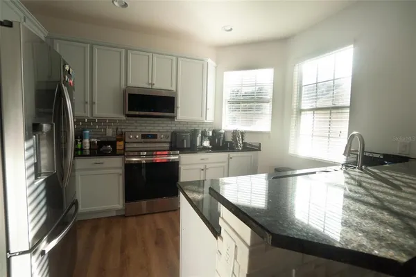 a kitchen with a stove a sink and a refrigerator