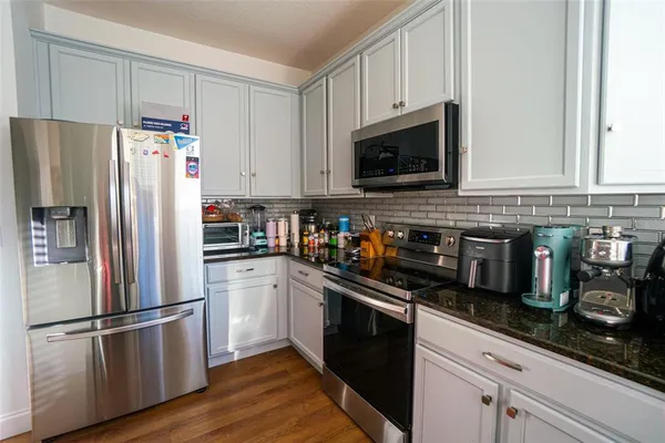 a kitchen with stainless steel appliances a refrigerator a stove a microwave and cabinets