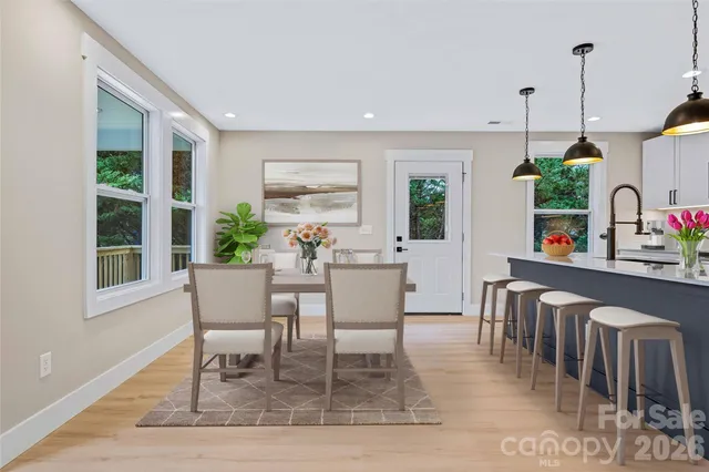 a dining room with furniture window and wooden floor