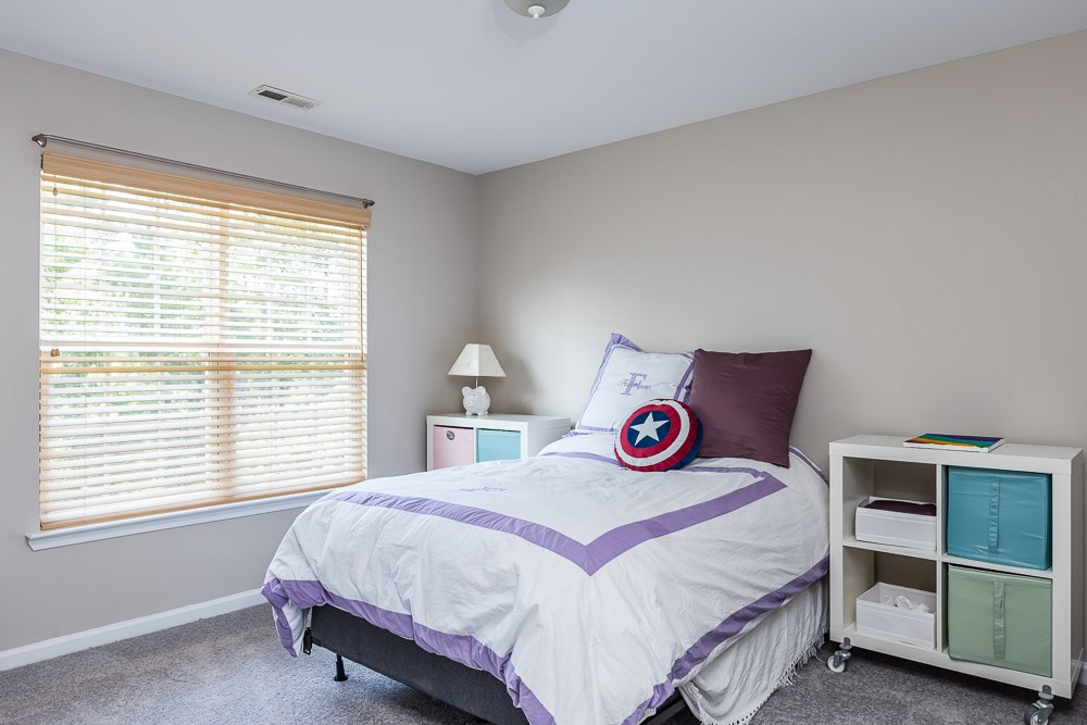 5419 Regatta Way Raleigh, NC 27613 - Photo 24 of 27 a bedroom with a bed a dresser and a window