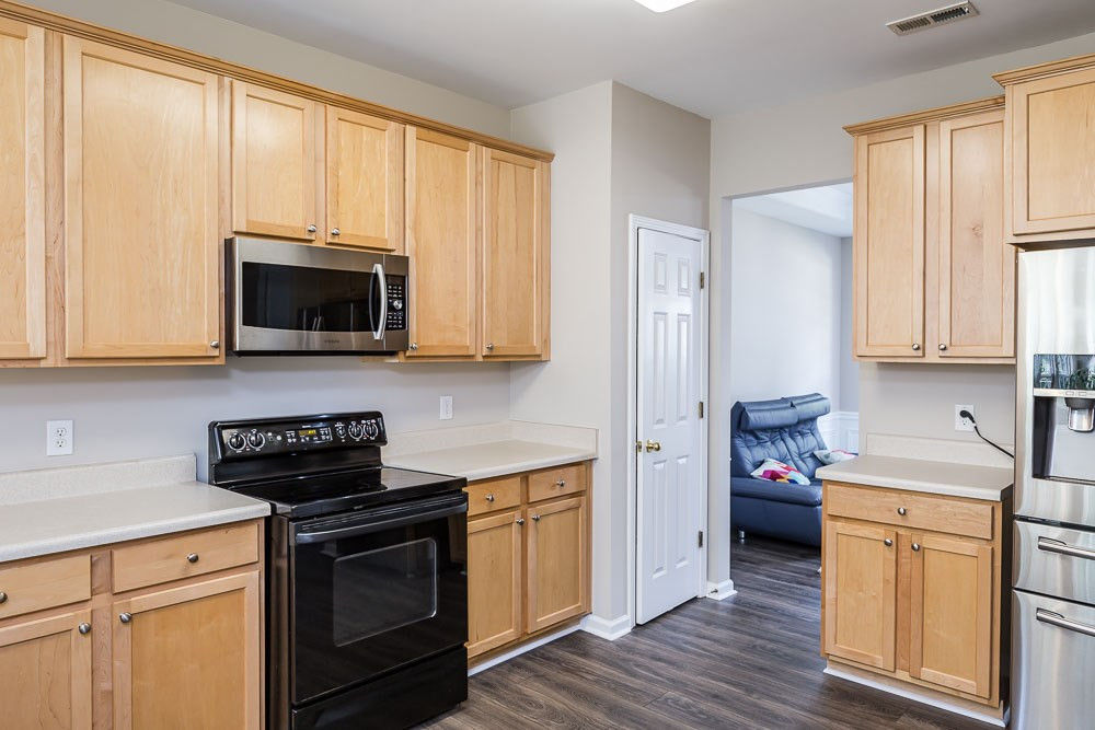 5419 Regatta Way Raleigh, NC 27613 - Photo 7 of 27 a kitchen with stainless steel appliances white cabinets granite counter tops and a window