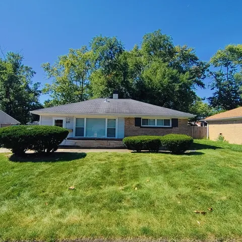 a view of a house with a yard and potted plants