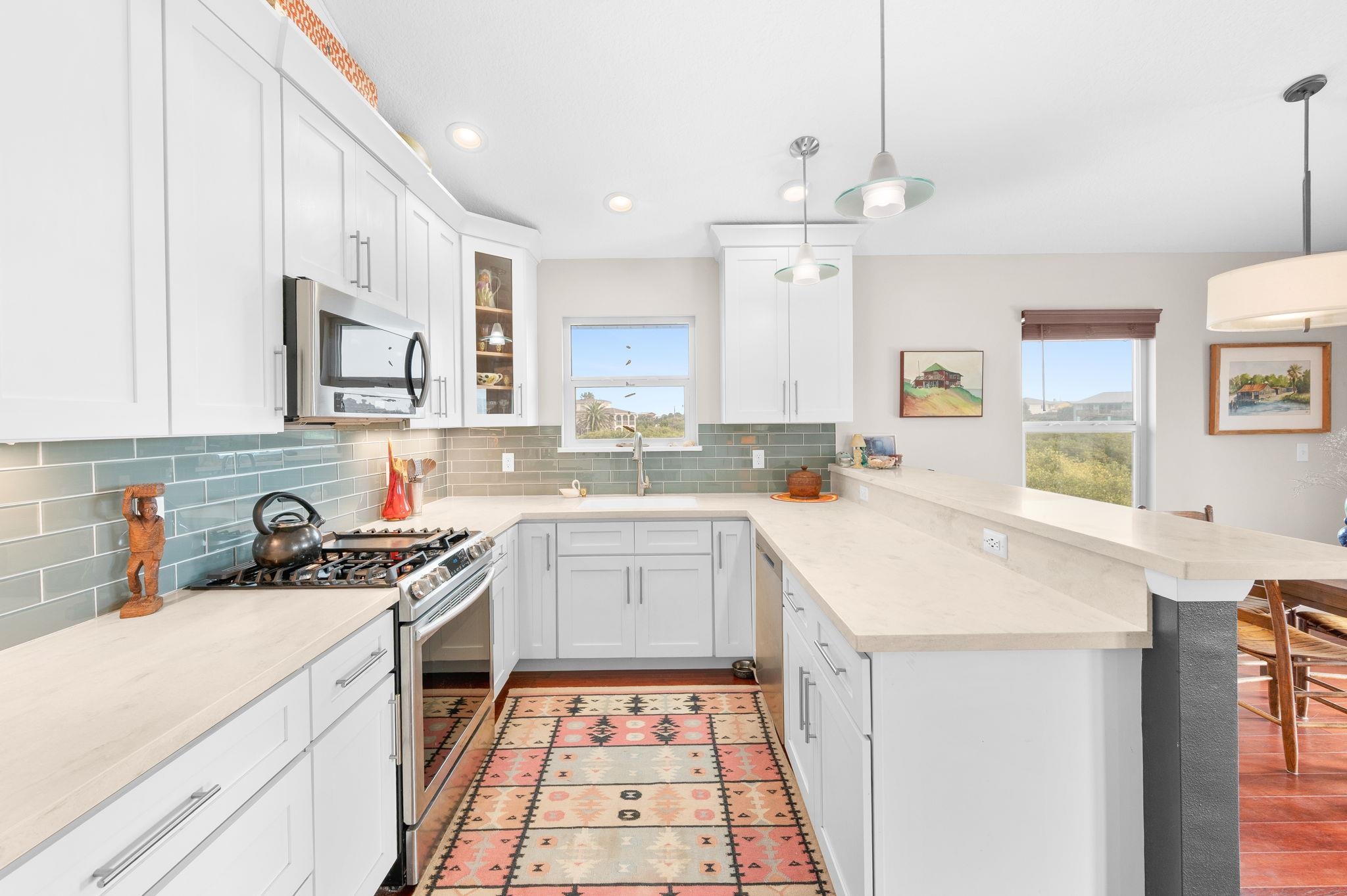 8950 Gene Johnson Road St. Augustine, FL 32080 - Photo 9 of 31 a kitchen with a sink a stove a refrigerator and white cabinets