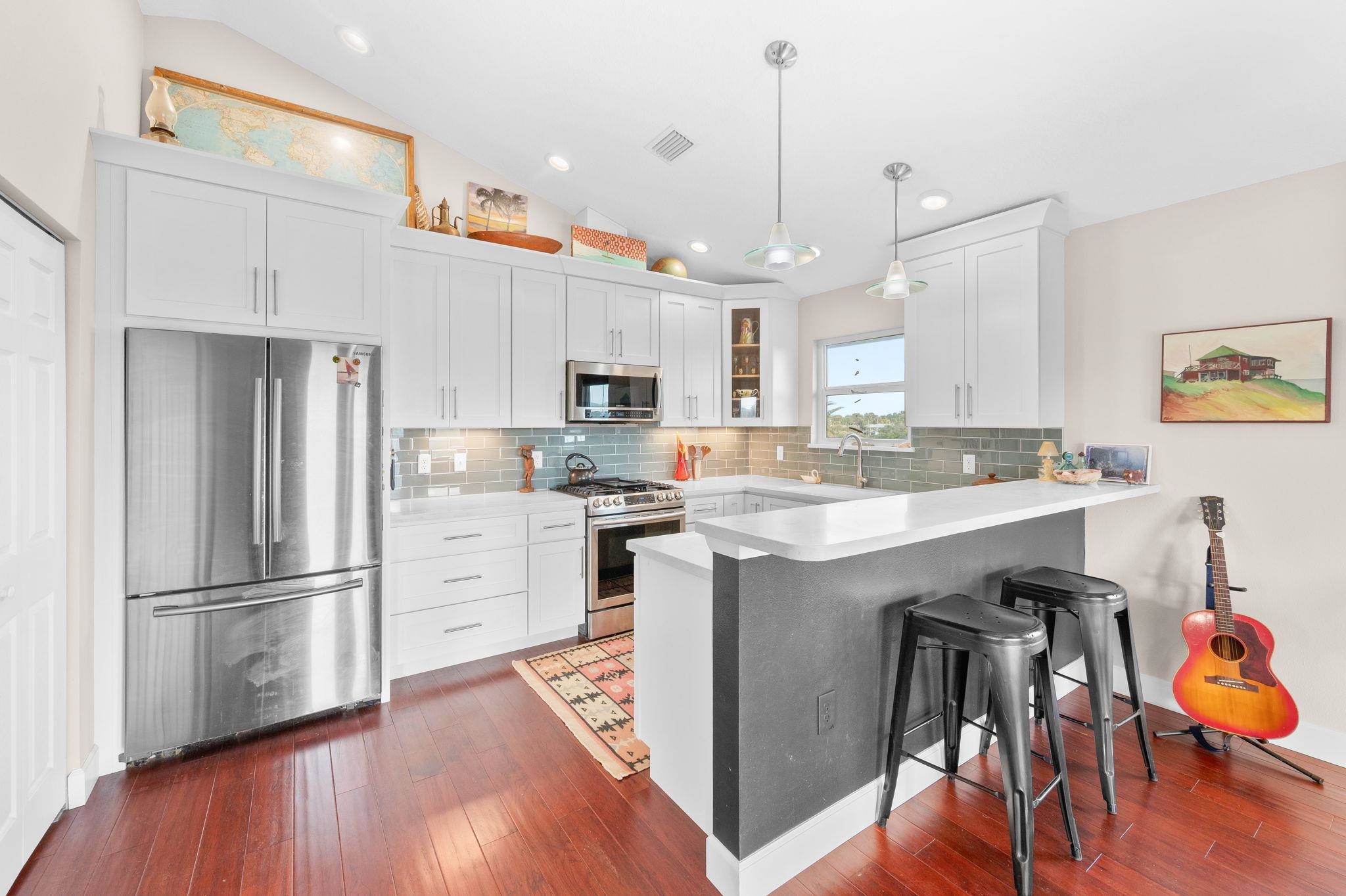 8950 Gene Johnson Road St. Augustine, FL 32080 - Photo 10 of 31 a kitchen with kitchen island white cabinets and stainless steel appliances