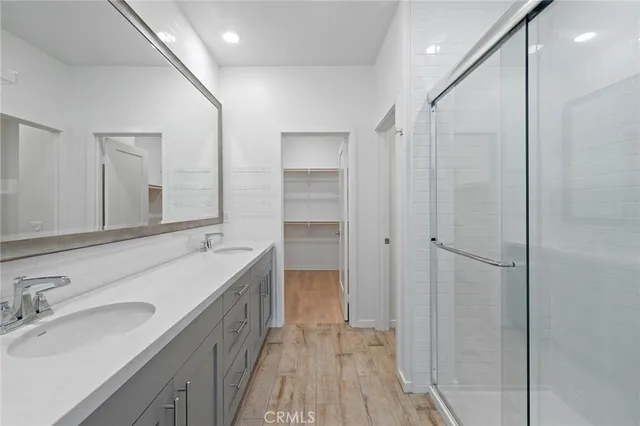 a bathroom with a double vanity sink a mirror and a shower
