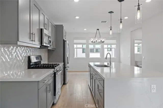 a kitchen with stainless steel appliances granite countertop a sink stove and cabinets