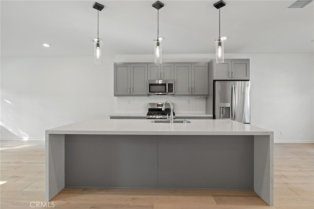 712 South Grable Circle Orange, CA 92868 - Photo 6 of 42 a kitchen with kitchen island a sink stainless steel appliances and cabinets