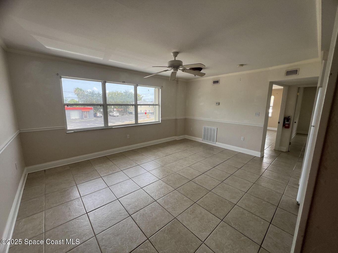 805 Forrest Avenue, Unit 4 Cocoa, FL 32922 - Photo 3 of 9 an empty room with windows and fan