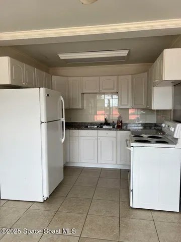 a kitchen with cabinets and a refrigerator