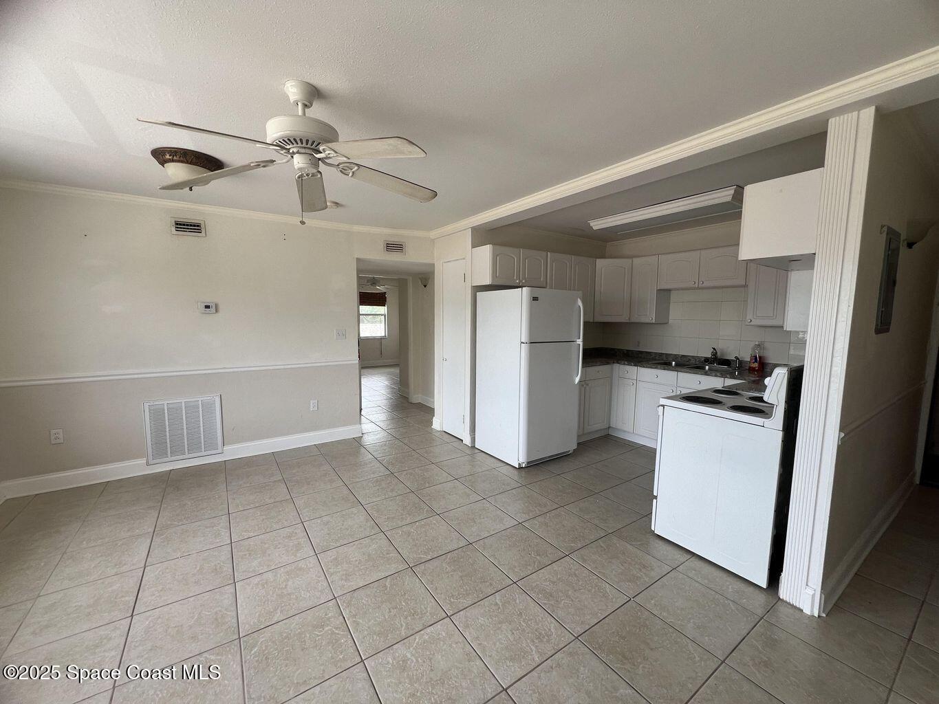 805 Forrest Avenue, Unit 4 Cocoa, FL 32922 - Photo 6 of 9 a kitchen with a refrigerator a stove top oven and cabinets