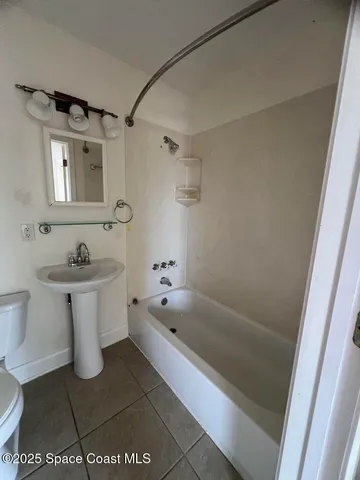 a bathroom with a bathtub a sink a toilet and mirror