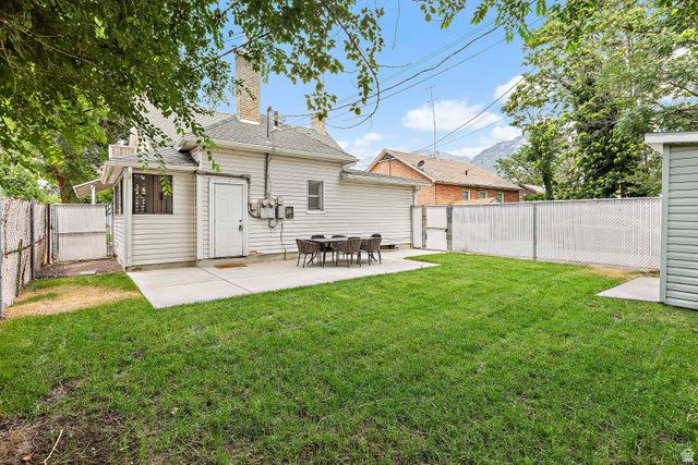 369 200 North Provo, UT 84601 - Photo 15 of 32 Spacious rear yard featuring a large concrete patio, manicured lawn, and perimeter chain link fencing