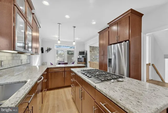 a kitchen with stainless steel appliances granite countertop a sink stove and refrigerator