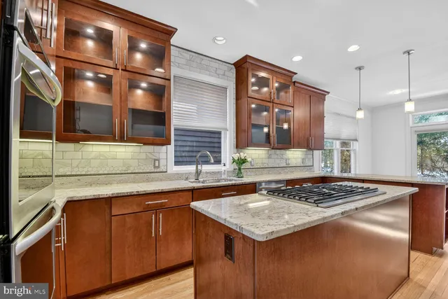 a kitchen with stainless steel appliances granite countertop a sink and a stove