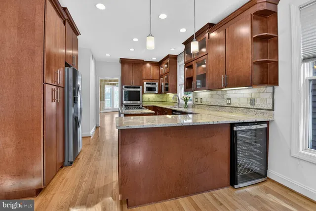 a view of an empty room with wooden floor and windows
