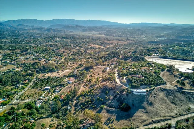 an aerial view of residential houses with outdoor space and ocean view