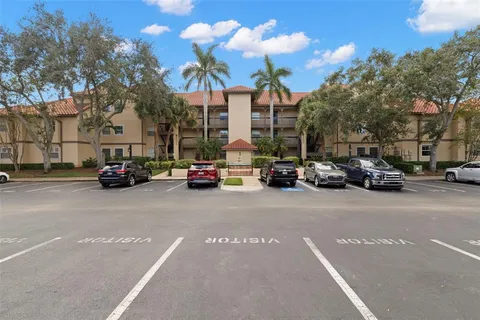 a view of road with card parked on side and retail shops