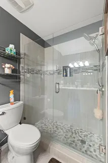 a bathroom with a toilet and a shower