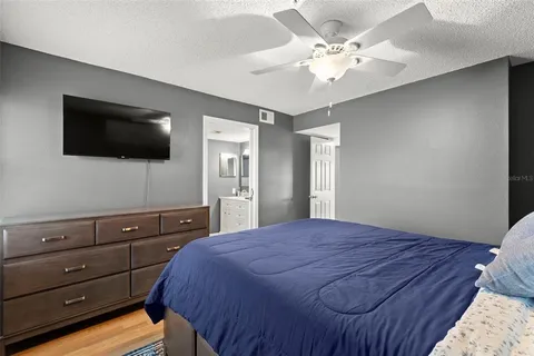 a bedroom with a bed a flat screen tv and a chandelier