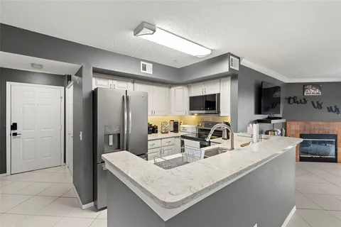 a kitchen with stainless steel appliances granite countertop a sink a stove and a refrigerator