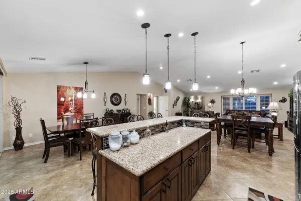 a living room with furniture kitchen view and a flat screen tv