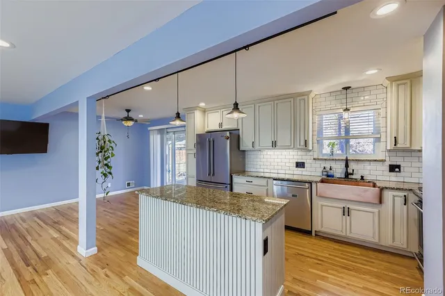 a kitchen with granite countertop a sink stove and cabinets