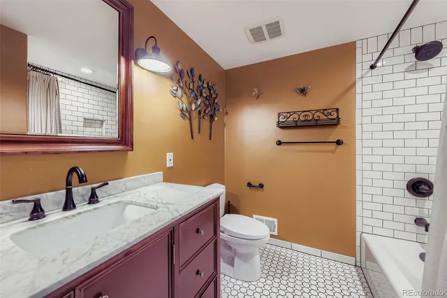 a bathroom with a granite countertop toilet sink and mirror