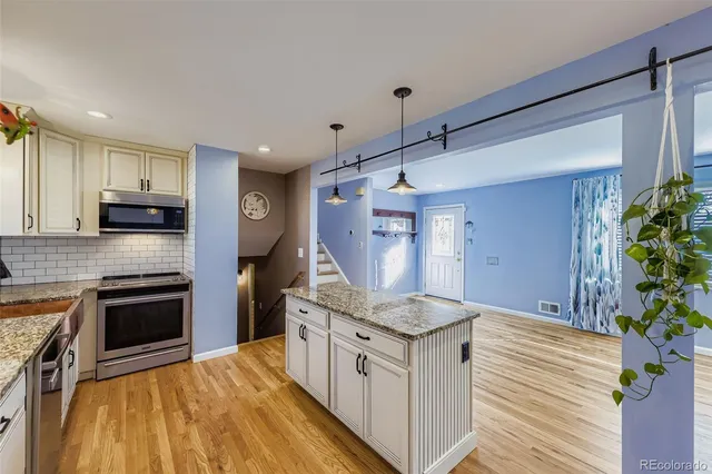 a kitchen with stainless steel appliances granite countertop a stove a sink and a refrigerator