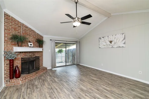 wooden floor fireplace and windows in an empty room
