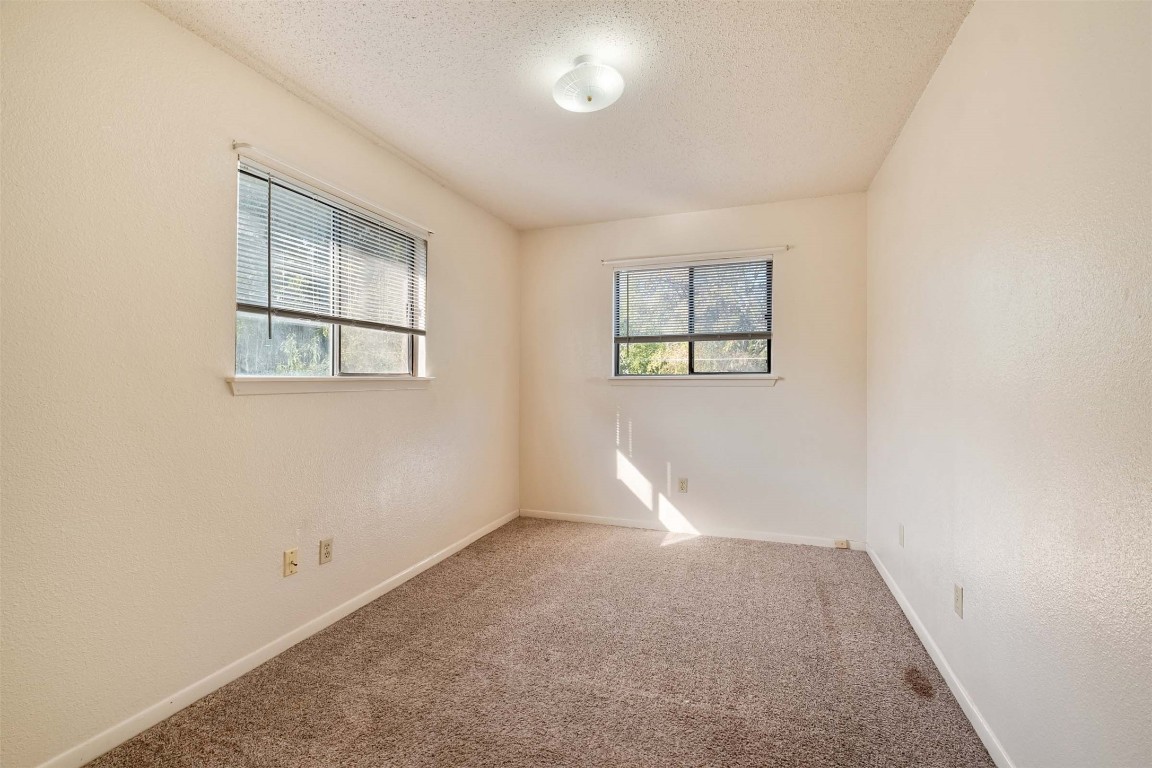 200 Concho Street, Unit B Lockhart, TX 78644 - Photo 11 of 13 Carpeted spare room with a textured ceiling and a textured wall