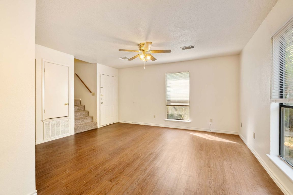 200 Concho Street, Unit B Lockhart, TX 78644 - Photo 4 of 13 Spare room with wood finished floors, stairway, a ceiling fan, and a textured ceiling