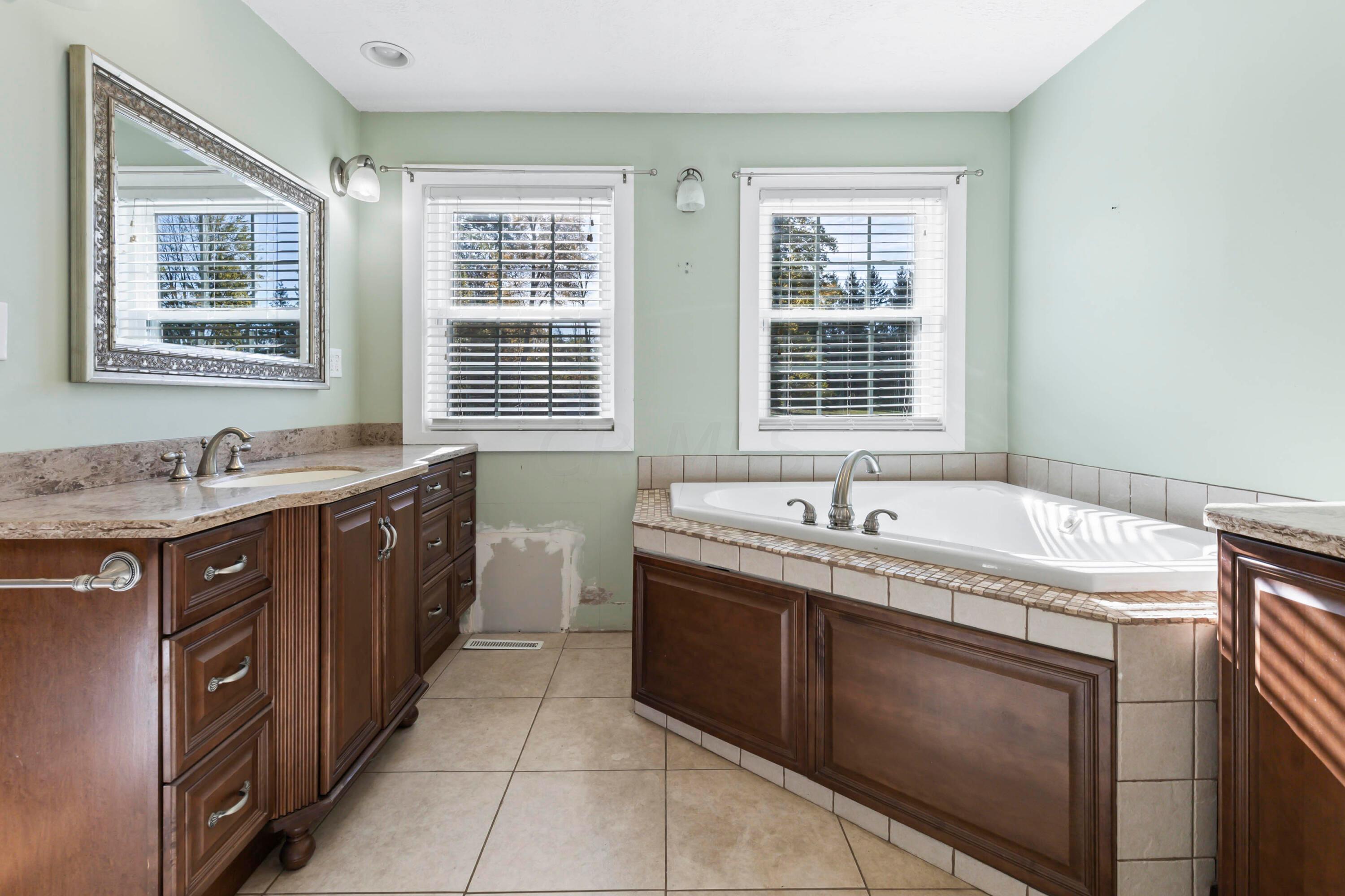 9495 Kilbourne Road Sunbury, OH 43074 - Photo 29 of 84 • Ceramic tile flooring
• Sage painted walls
• Whirlpool tub
• Two person, walk-in shower
with custom tile
• His & Hers enclosed vanities
with cultured marble sinktop
• 3 bulb wall light
• (4) lighted wall sconces
• Ventilated shelving