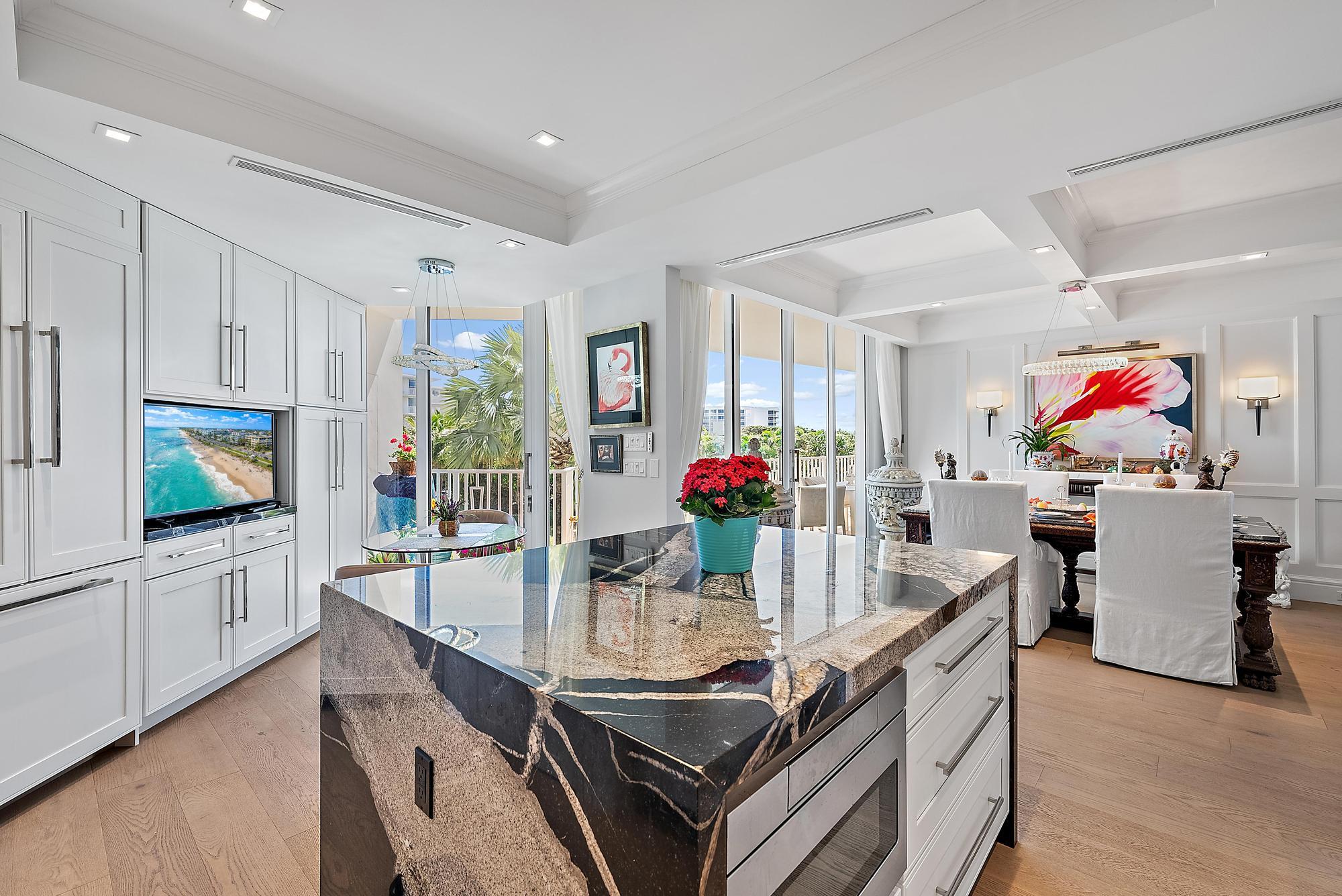 2500 South Ocean Boulevard, Unit 1 D 2 Palm Beach, FL 33480 - Photo 10 of 42 a view of a dining room and kitchen with furniture a chandelier and wooden floor