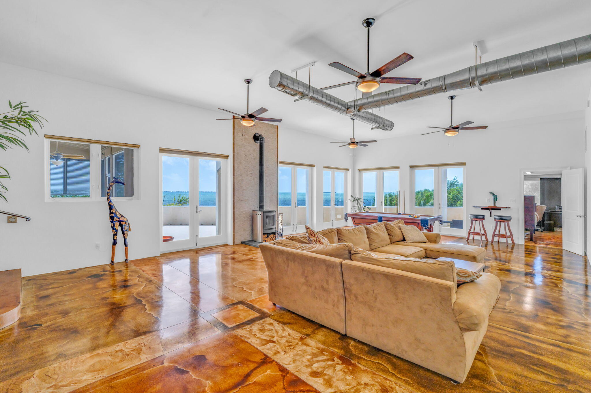 225 Colson Drive Cudjoe, FL 33042 - Photo 4 of 71 a living room with couches a fireplace and a dining table with wooden floor