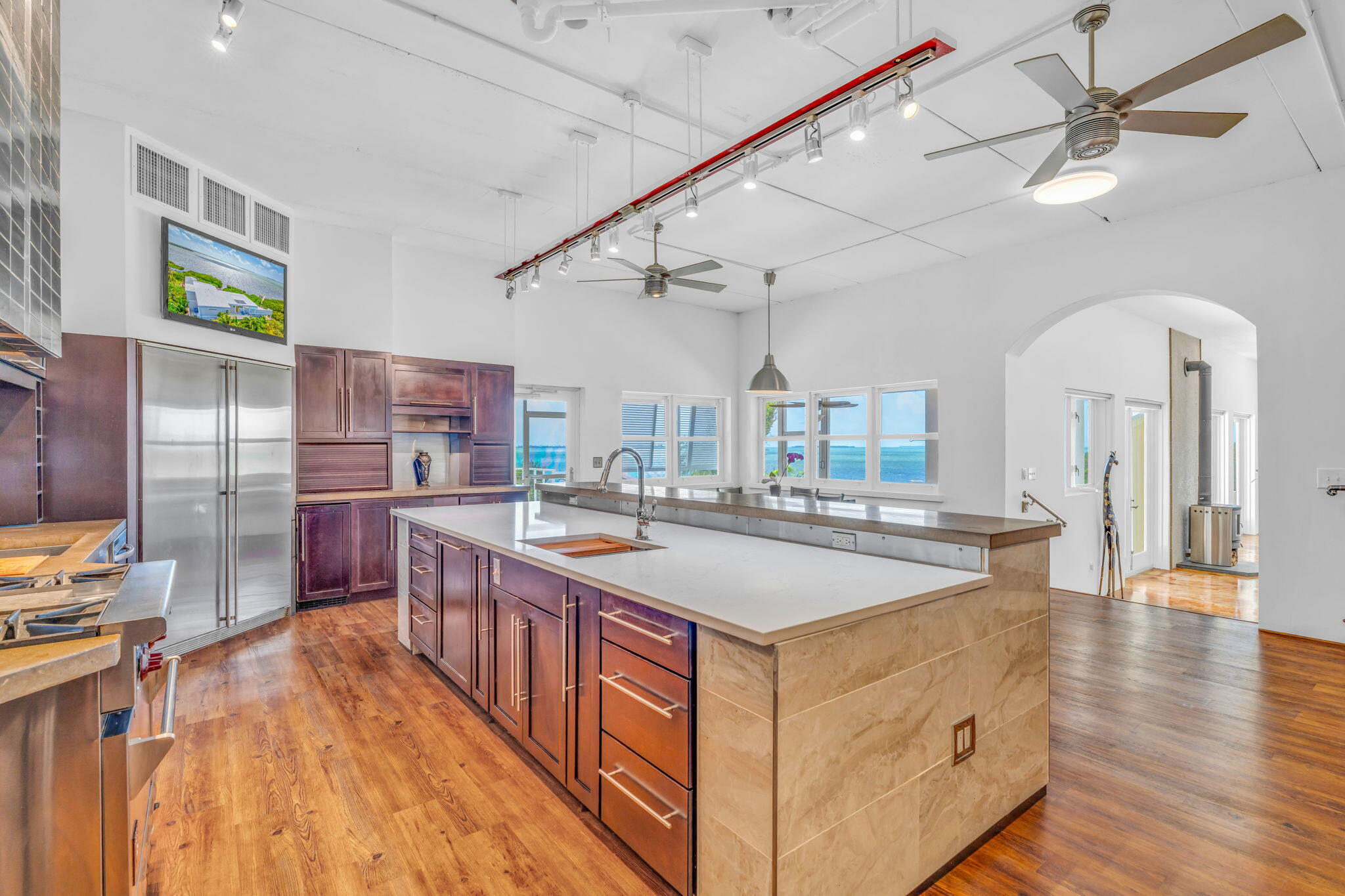 225 Colson Drive Cudjoe, FL 33042 - Photo 9 of 71 a large kitchen with stainless steel appliances a stove a sink dishwasher and a dining table with wooden floor