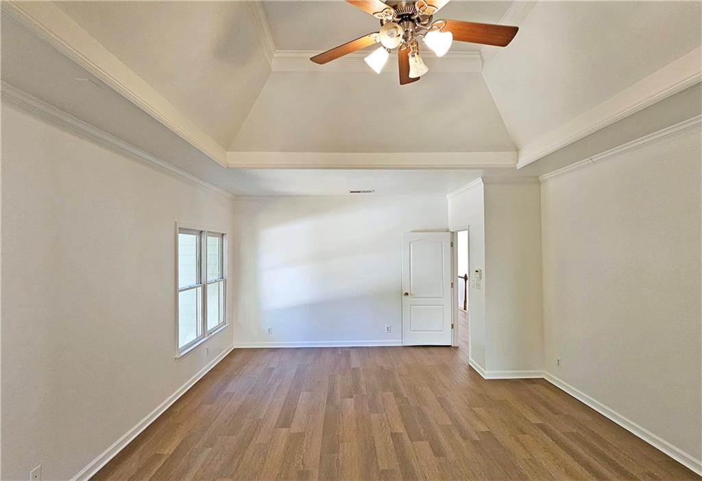195 Beracah Walk Atlanta, GA 30331 - Photo 20 of 32 an empty room with wooden floor chandelier fan and windows