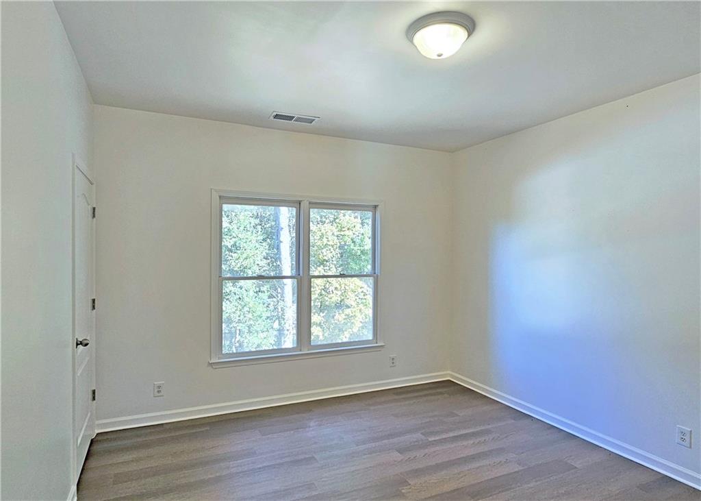195 Beracah Walk Atlanta, GA 30331 - Photo 21 of 32 an empty room with wooden floor and windows