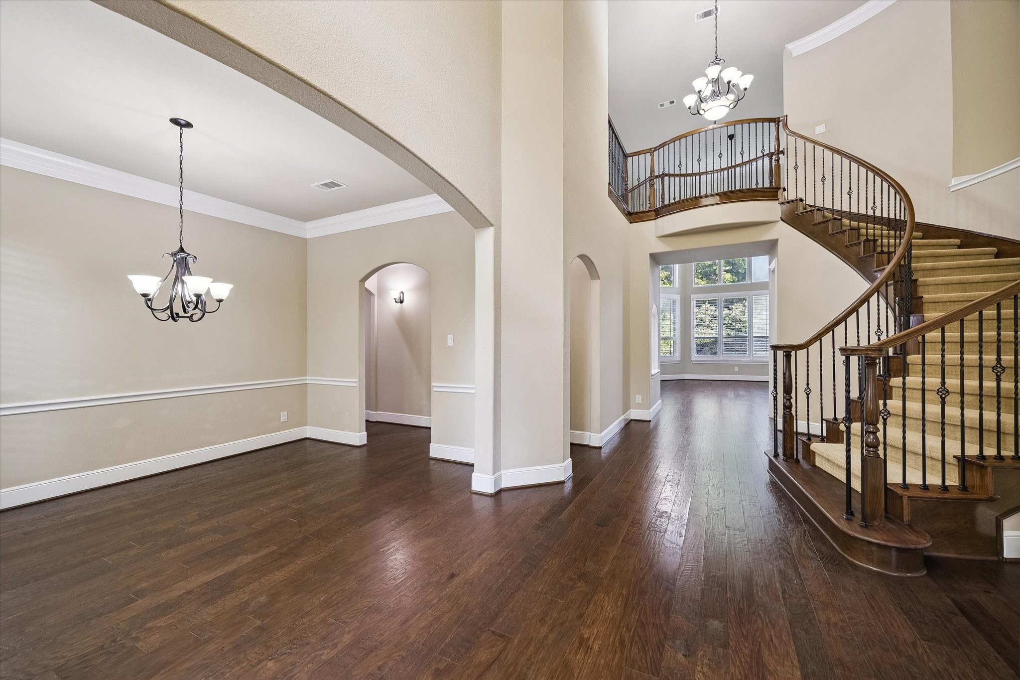 35 North Fremont Ridge Loop Spring, TX 77389 - Photo 4 of 37 The home's impressive foyer welcomes guests with soaring ceilings, rich hardwood floors, and a graceful curved staircase. The formal dining room, thoughtfully positioned near the entrance, offers an elegant space for entertaining and memorable gatherings.